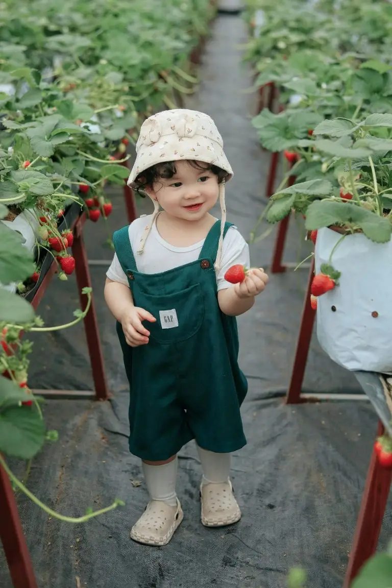 petite fille asiatique tenant une fraise