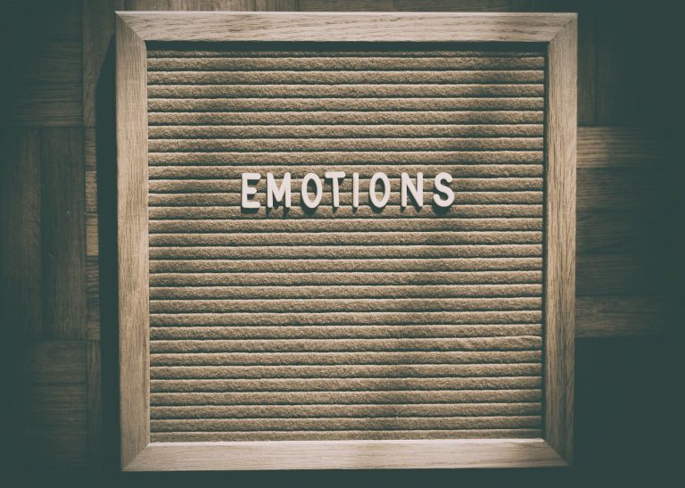 brow n cardboard with letters writing emotions in white